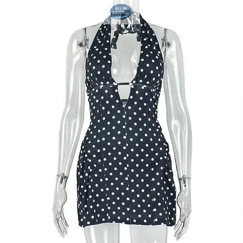 Studio shot of the black and white polka dot halter dress on a transparent mannequin - Highlighting the adjustable neck tie, deep V-cut, and slimming A-line silhouette - High-quality printed summer mini dress - ALL IN 1 WORLD
