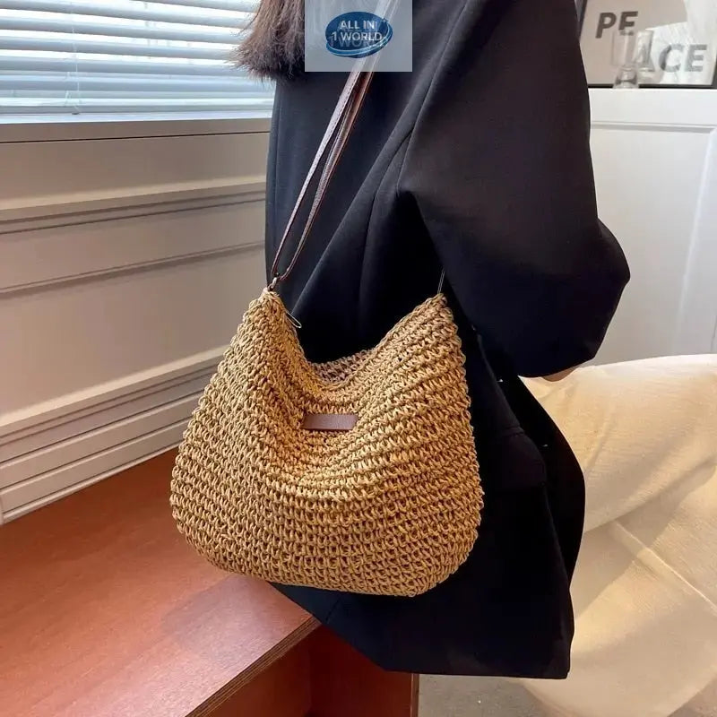 Lifestyle shot of a woman wearing the tan brown summer straw shoulder bag over a black blazer - Showcasing the bag's perfect size and drape for daily use - Elegant bohemian-chic accessory - ALL IN 1 WORLD