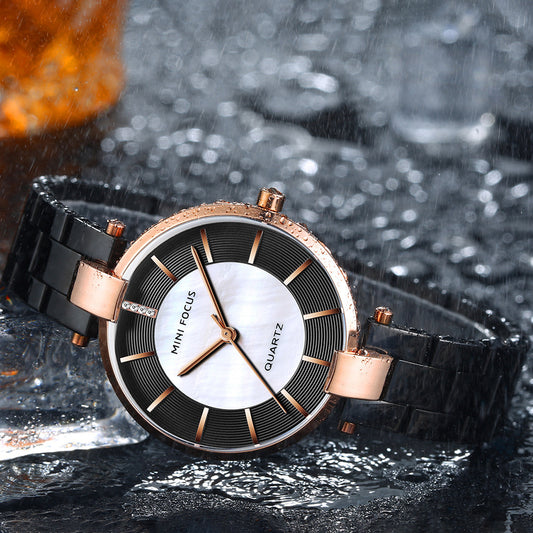 Black and rose-gold women's quartz watch on a dark surface