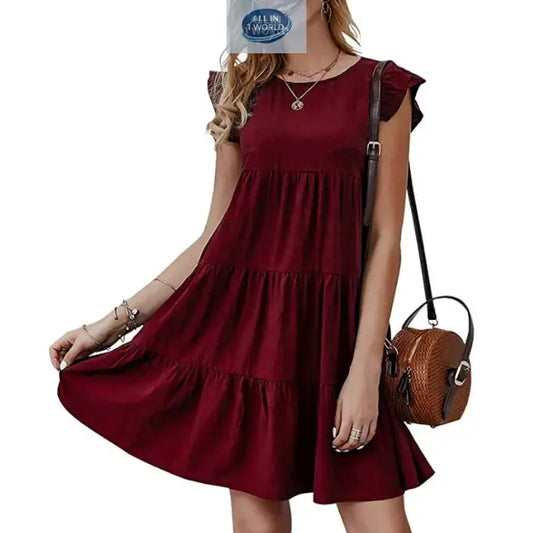 Short burgundy flowy tiered dress for women featuring delicate cap sleeves and a round neckline - Elegant loose-fit summer mini dress styled with a round leather bag - ALL IN 1 WORLD
