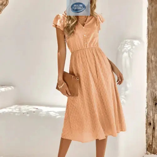 Full front view of a charming apricot Swiss dot midi dress with ruffled cap sleeves and a V-neckline - Flowy A-line summer dress for women featuring an elasticated waist - Elegant soft-toned vacation outfit - ALL IN 1 WORLD