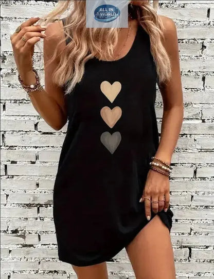 Front view of a classic black sleeveless tank dress featuring a stylish triple heart graphic print - Soft, breathable crew neck mini dress for women - Effortless summer street style - ALL IN 1 WORLD